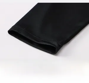 Detailed close-up of the smooth hem and reinforced stitching on black compression pants