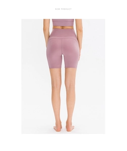 Detail of high-waisted yoga shorts in dusty pink with peach lift stitching and high stretch
