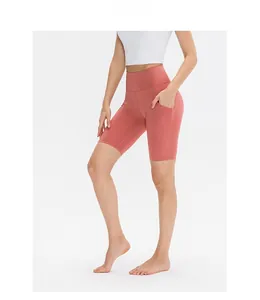 Dettaglio dei pantaloncini da yoga a vita alta rosso corallo con tasche laterali