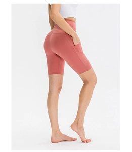 Dettaglio dei pantaloncini da yoga a vita alta rosa corallo con tasca laterale ed elastico
