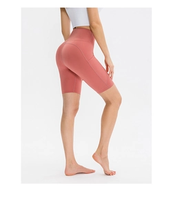 Dettaglio dei pantaloncini da yoga a vita alta con tasche laterali in tessuto rosa antico