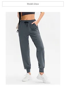 Dettaglio dei pantaloni da yoga grigio scuro con coulisse regolabile e grandi tasche