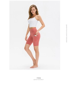 Dettaglio dei pantaloncini da yoga rosa a vita alta con pratica tasca laterale per cellulare