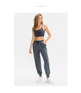 Dettaglio dei pantaloni da yoga larghi con coulisse nera regolabile e tasche laterali