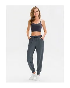 Dettaglio dei pantaloni da yoga grigio scuro con coulisse e reggiseno sportivo coordinato