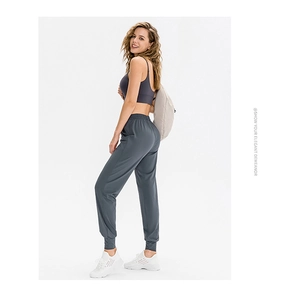 Dettaglio ravvicinato del gilet sportivo grigio scuro e dei pantaloni da yoga coordinati