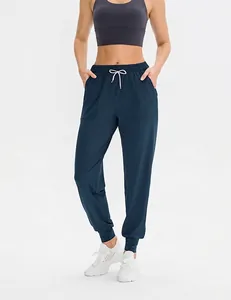 Dettaglio dei pantaloni da yoga a vita alta con coulisse bianca e tasche per il fitness
