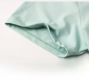 Détail du poignet du t-shirt de yoga vert menthe montrant la double couture et le tissu