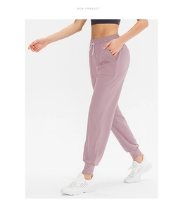 Dettaglio dei pantaloni da yoga larghi con coulisse in vita e tasche laterali lilla