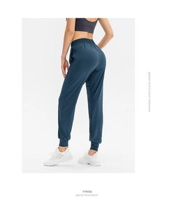 Vue latérale du pantalon de sport bleu foncé montrant la coupe ajustée et le tissu souple