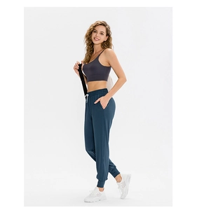 Détail d'un pantalon de yoga pour femme avec taille haute à cordon et poches latérales