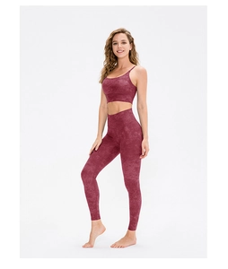Détail d'un ensemble de yoga rouge foncé avec brassière et legging marbrés sur modèle