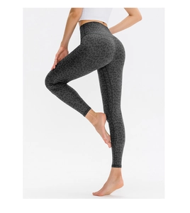 Macro shot of high-waist yoga leggings showing dark grey leopard print and elastic fabric