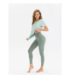Détail du t-shirt de yoga vert menthe et legging gris avec poches latérales pratiques