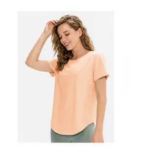 Détail du haut de yoga pour femme avec col rond et ourlet arrondi en couleur abricot