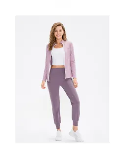 Yoga-Set mit rosa Jacke, weißem Crop-Top und lila Jogginghose für Fitness und Training