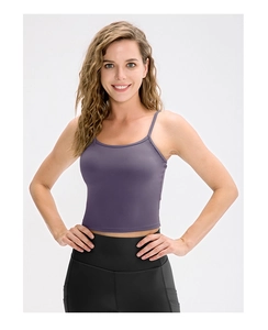Dettaglio di un top da yoga viola con spalline sottili e leggings sportivi neri a vita alta