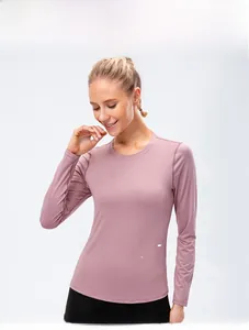 Gros plan sur le haut de yoga rose à manches longues avec taille ajustée et tissu respirant