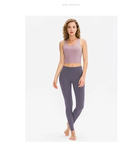 Detail view of high-waist lilac sports bra and dark purple leggings set on white background