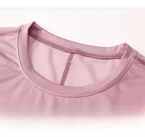 Vue macro du tissu en maille respirante sur un haut de yoga rose poudré à col rond