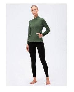Detail view of green zip-up sports jacket and black yoga leggings with side pockets
