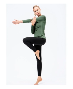 Women's dark green long sleeve compression yoga top and black high waist leggings outfit