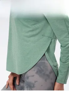 Dettaglio dello spacco laterale sulla maglia da yoga a maniche lunghe in maglia a nido d'ape