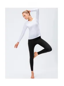 Detail of white V-neck long sleeve yoga top and black high waist leggings with side pockets