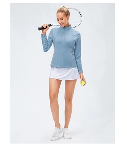 Light blue slim-fit zip-up long sleeve sports top and white tennis skirt ensemble