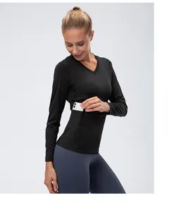Detail showing women's long sleeve black yoga top with functional side pocket for smartphone