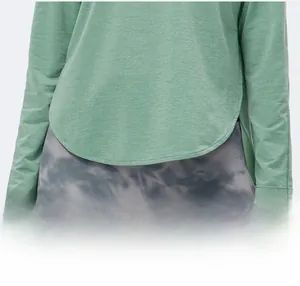 Dettaglio di una maglia da yoga verde salvia con orlo curvo e spacchetti laterali pratici