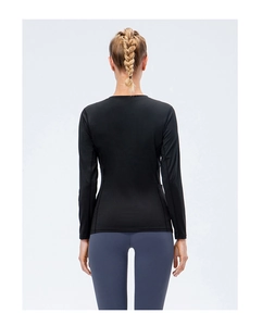 Slim fit black long sleeve sports top for women showing back view in athletic wear