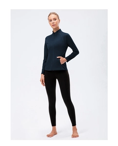 Full-body shot of a women's dark blue zip-up yoga jacket and black compression leggings