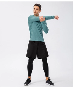 Men's athletic set with grey-green long sleeve top and layered black training leggings