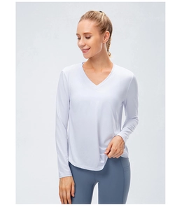 Détail du haut de yoga blanc à manches longues montrant le tissu respirant et la coupe