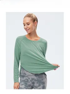 Dettaglio maglia yoga a maniche lunghe verde salvia con spacco laterale e pieghe