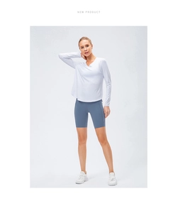 Haut de yoga blanc à manches longues col en V et short de cycliste bleu pour fitness