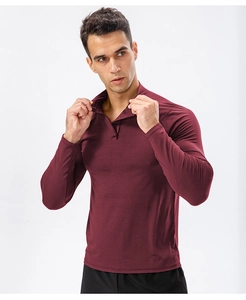 Detailed view of men's slim fit half-zip sports top in deep burgundy breathable fabric
