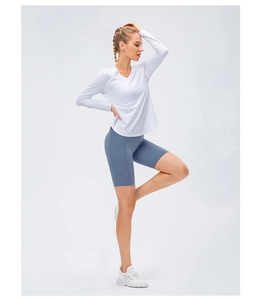 Détail d'un haut de yoga blanc à manches longues et d'un short de cyclisme bleu à poche