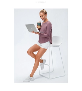 Women's purple long sleeve yoga top with curved hem and crew neck on model