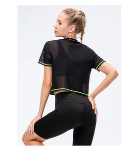 Macro view of breathable mesh sports top with neon green piping on black fabric