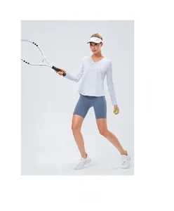 Tenue de sport pour femme avec haut blanc à manches longues col V et short bleu taille haute