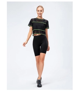 Detail of black mesh workout top with neon green stripes and matching biker shorts