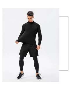 Detail view of men's black 1/4 zip long sleeve compression top and shorts set