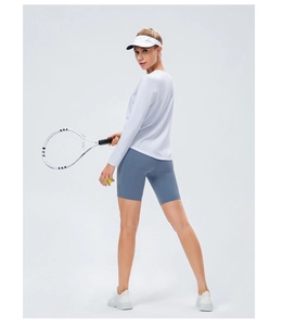 Tenue de yoga femme avec haut blanc à manches longues et short bleu de sport