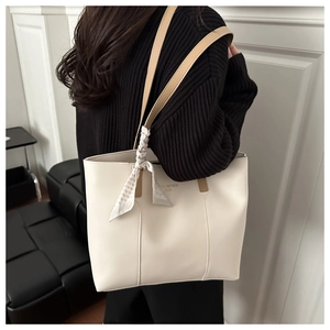 Detail of cream tote bag with brown straps and chic houndstooth silk scarf accessory