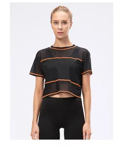 Detail of black mesh cropped sports top featuring breathable fabric and orange contrast seams
