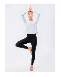 Detail of loose fit quick dry yoga long sleeve top with black pocket leggings