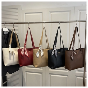 Five assorted large tote bags in leather finish with decorative silk scarves on handles