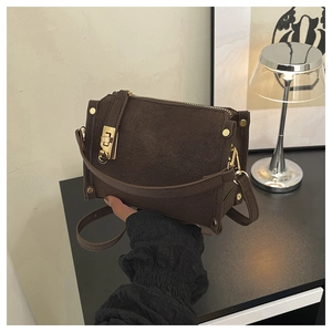 Detail of vintage coffee brown box bag featuring gold rivets and metallic buckle clasp